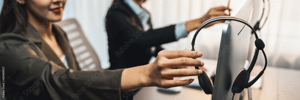 Aufkleber panorama focus hand holding headset on call center workspace desk with blur background of operator t