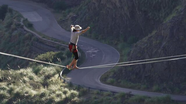 A young man taking a fall on a highline over a road in slow motion. Extreme sports. Argentina.