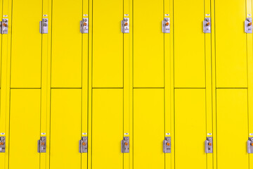 Yellow lockers with locks in a school hallway