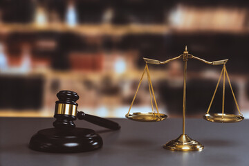 Shiny golden balanced scale and wooden gavel in law firm or lawyer office background as concept...