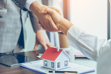 Real estate agent shakes hands with customer after finished contract after about home insurance and investment loan - obrazy, fototapety, plakaty