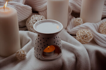 Aroma lamp with essential oil, aromatherapy at home, burning candle, dropping essential oil. Concept of home relaxation and anti stress. Natural Spa treatment Home fragnance at cozy home on the