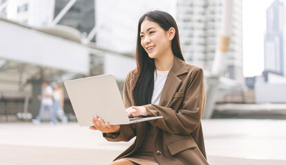 Business freelance asian woman using laptop computer sitting at outdoor