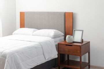 A spacious bedroom with a modern bed and an open end table on the opposite side