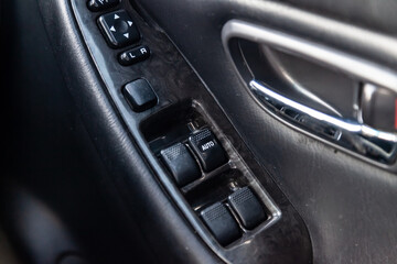 Plakat Close-up of the side door buttons: window adjustment buttons, door lock. Window control panel in a modern car. Automatic car window controls and details. Selective focus