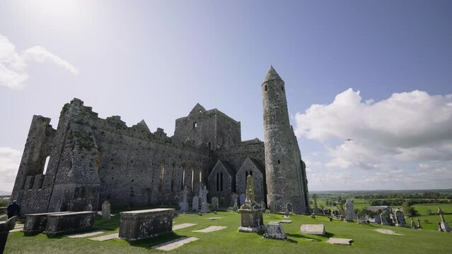 Tourists walk around cemetery of old Irish cathedral
