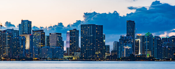 Miami waterfront skyline at dusk with dark clouds and a blue sky