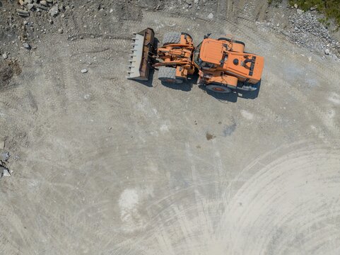 Aerial view of bulldozer on construction site and mining industry. Heavy machinery for earth moving.