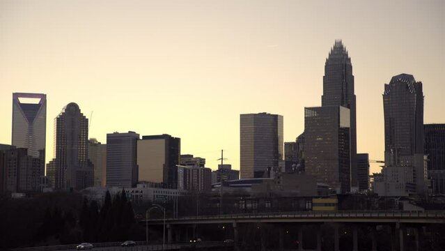 Lockdown Shot Of Vehicles Moving On Bridge By Skyscrapers In City At Sunset - Charlotte, North Carolina