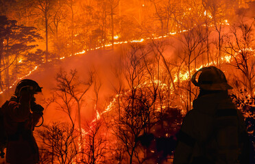 Firefighters battle a wildfire because El nino events , climate change and global warming is a...