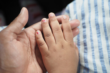 father holding hand of baby child, close up .