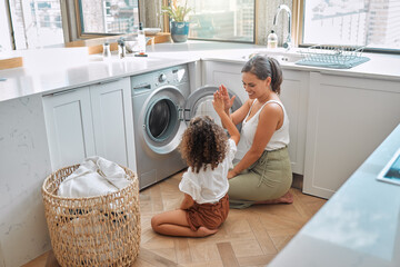 High five, laundry and washing machine with mother and daughter for helping, learning and cleaning....