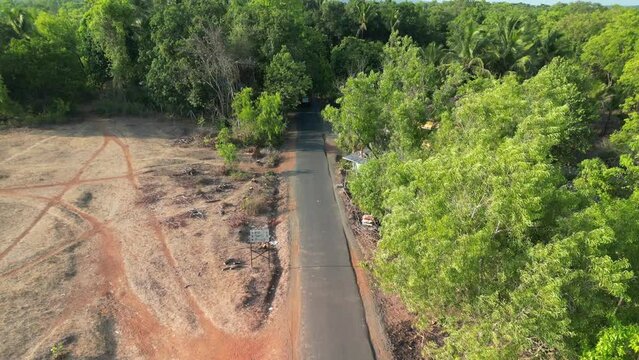S T rural red bus moving in a Malvan village drone following view morning lal pari in summer may
