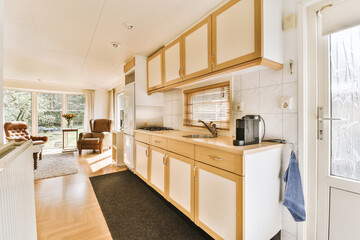 a kitchen with wood cabinets and white appliances on the counter top in front of the door to the living room