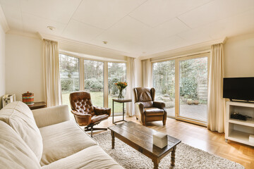 a living room with two couches, a coffee table and a flat screen tv on the wall behind it
