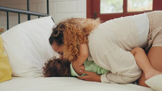 Happy Mom teasing daughter kiss and ticklish play having fun happy laughing on bed in bedroom at home.Family concept