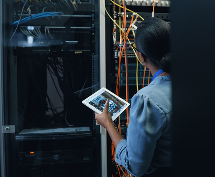 Server room, engineer and woman with a tablet for programming, cybersecurity or cable maintenance. Black female technician or IT in datacenter for network, software system upgrade with technology