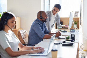 Call center, crm or support with a manager and consultant at work in an office for assistance. Contact us, customer service or consulting with hr management training an employee in telemarketing