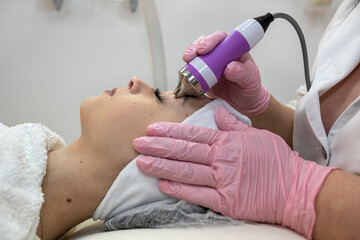 cosmetologist make rejuvenation procedure on face with hardware