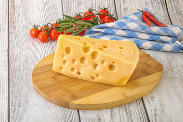 Maasdam cheese piece over board