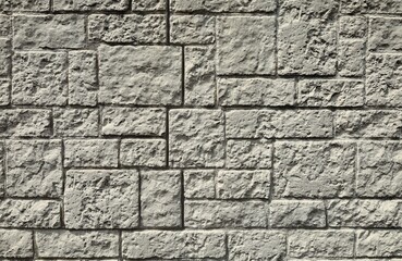 Exterior wall made of light gray stone blocks of different shapes geometrically arranged. Background and texture.binary comment