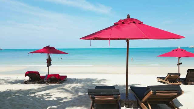 Cinematic shot hot summer day on beach with beach umbrellas and blue sea water. The camera moves inside the luxury summer resort hotel room with a private pool against the backdrop of the beach.