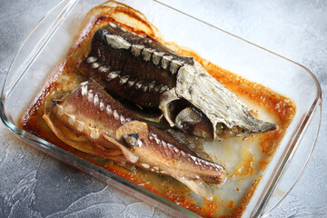 Sturgeon prepared in transparent glassware cooking pot. Grilled fish. Top view.
