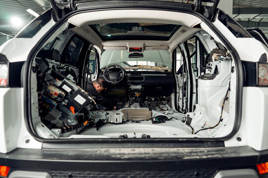 Car service worker installing noise insulation soundproofing in the car