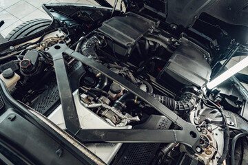 Car with open hood in car service station