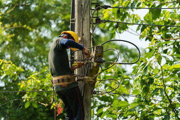 technician climbing electric poles and connecting wires