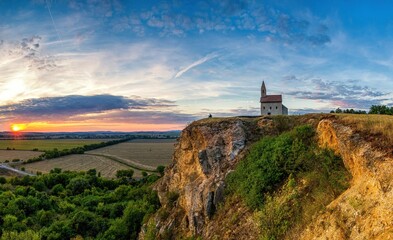 Fototapeta na wymiar Historic roman church on the hill over village Drazovce near Nitra city at Slovakia and breathtaking colorful sunset