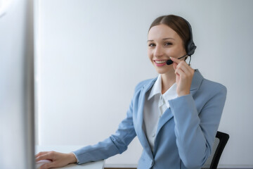 Call center agent woman with headset working on support hotline in modern office. Smiling female customer support phone operator at workplace.