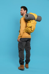 Naklejka premium Man with backpack on light blue background. Active tourism