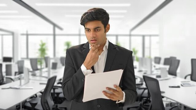 Stressed and tensed Indian manager reading contracts