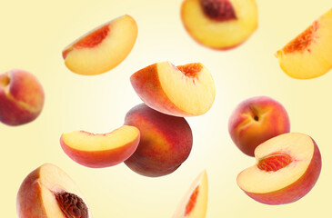 Juicy fresh peaches falling on pale light orange background