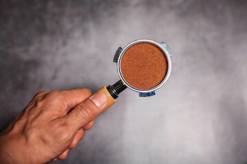 Hands hold portafilter with ground coffee for espresso coffee maker 