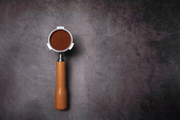 portafilter with ground coffee for espresso coffee maker on loft background