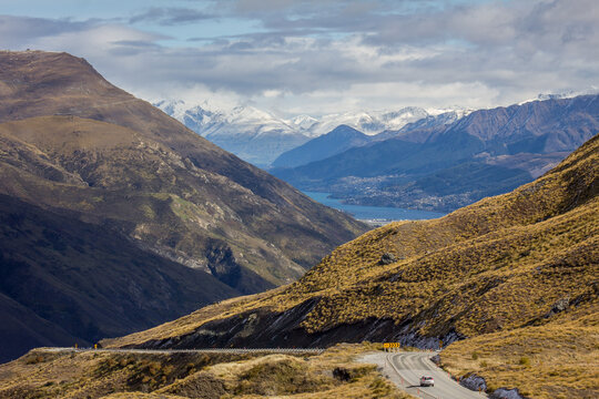 Queenstown, South Island, New Zealand Lake Wakatipu snow-capped mountains valley landscape view from campervan on road near Cardrona blue sky and white clouds, autumn fall
