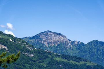 Beautiful mountain panorama with woodland, peak and Seelisberg village in the Swiss Alps at lakeshore of Lake Lucerne on a sunny spring morning. Photo taken May 22nd, 2023, Sisikon, Switzerland.