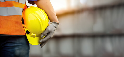 Construction worker or builder holding yellow hard hat, closeup detail to hand in protective gloves and helmet. Generative AI