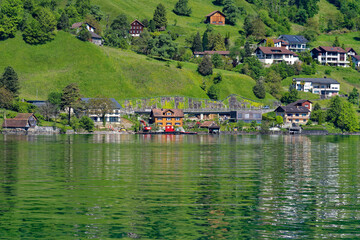 Scenic view of village Bauen seen from passenger ship on Lake Lucerne on a sunny spring day. Photo taken May 22nd, 2023, Bauen, Canton Uri Switzerland.