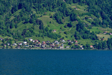 Scenic view of village Bauen seen from passenger ship on Lake Lucerne on a sunny spring day. Photo taken May 22nd, 2023, Bauen, Canton Uri Switzerland.