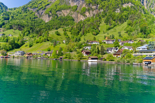 Scenic view of village Bauen seen from passenger ship on Lake Lucerne on a sunny spring day. Photo taken May 22nd, 2023, Bauen, Canton Uri Switzerland.