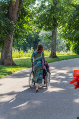 lady with senior person in rollator in summer city park