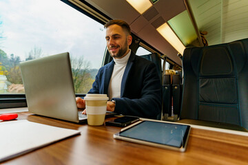 Passenger on a train is working remotely on his laptop on his daily commute to work