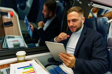 Project manager going over results and data on a lead project via video call on a commute by train, he's happy with results