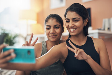 Peace sign, exercise selfie and women together at home for social media memory, emoji or post. Indian sisters or female friends taking photo for influencer update, fitness motivation or happy results