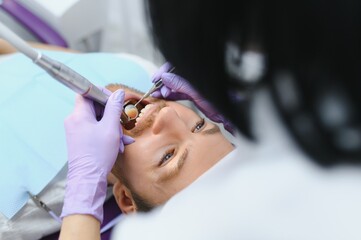 Fototapeta premium Periodontal Services. Closeup Shot Of Smiling Man Getting Treatment In Stomatologic Clinic, Dentist Doctor In Gloves Using Sterile Dental Tools For Examining Teeth Of Male Patient