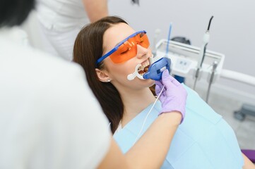 Teeth whitening for woman. Bleaching of the teeth at dentist clinic.