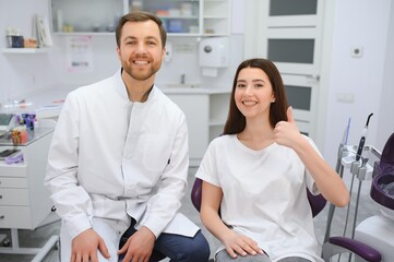 people, medicine, stomatology and health care concept - woman patient talking to male dentist and complain of toothache at dental clinic office.